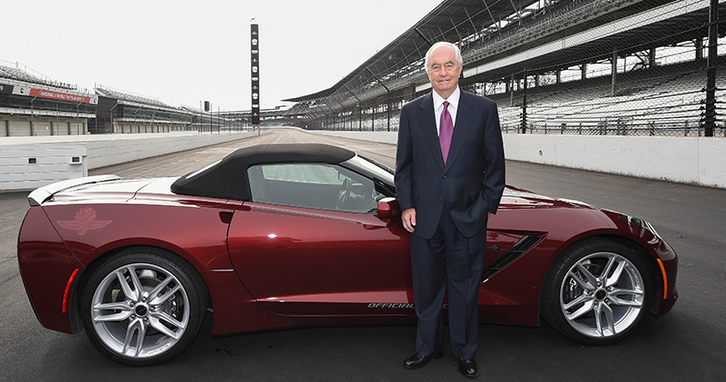 roger penske standing in front of a car on the indianapois motor speedway