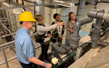 The research and support team examining the pilot plant settling basin. The ozone columns are visible to the upper left. Left to right, Michael Dunne, Carol Miller, Dienye Tolofari, Yongli Wager. // Photo by John Norton/GLWA