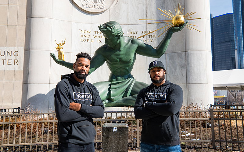 Calvin Johnson and Rob Sims pose in front of The Spirit of Detroit statue.