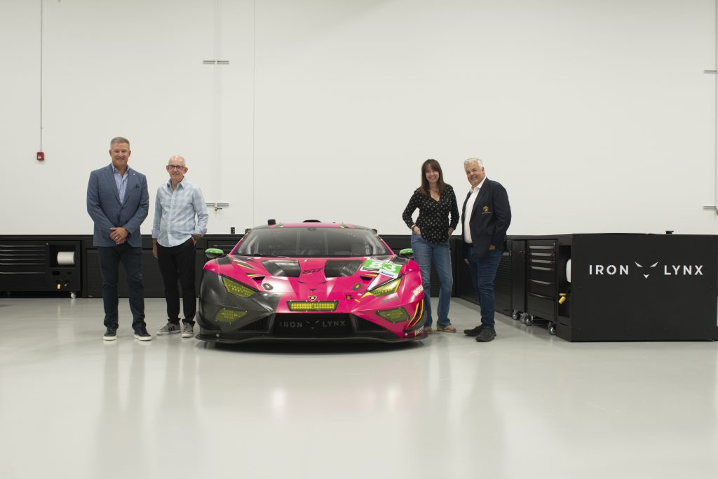 Race team in front of car