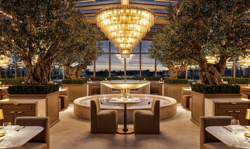 The RH Rooftop Restaurant at RH Detroit features sparkling chandeliers, heritage olive trees, a trickling center fountain, and a menu of American and Mediterranean classics.