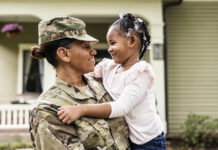 General Motors Launches Stars, Stripes, and Skilled Trades Initiative Portrait of female U.S. soldier in uniform with young daughter in front of home