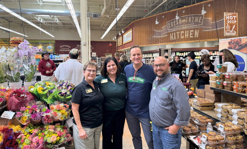 People posing for a photo inside Fresh Thyme Market