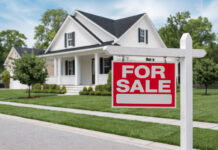 Report: Metro Detroit Home Sales Steady in August, Prices Down 3% from July A bungalow-style home with a "For Sale" sign in front of it.
