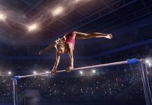 USA Gymnastics Bringing National Championships to Detroit May 13-16, 2027 A gymnast doing a bar routine.